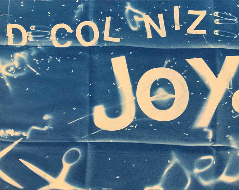Photo of blue material that says 'decolonize joy and sex'